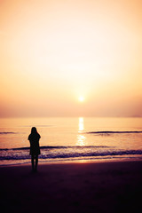 Fototapeta premium silhouette of woman alone and wave on the beach