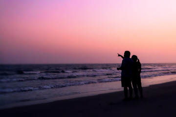 silhouette of couples hugging on the beach