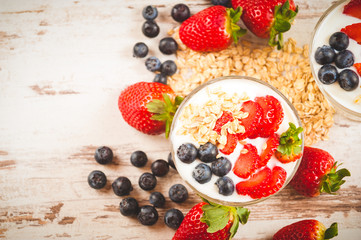 Strawberries, blueberries and breakfast cereal in yogurt on a wo