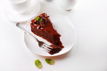 Delicious chocolate cake on plate on table on light background