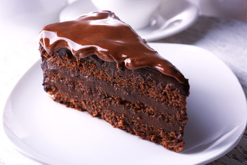 Delicious chocolate cake on plate on table on light background