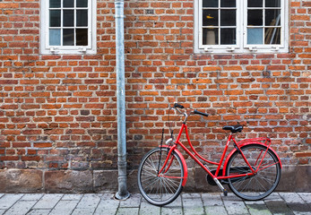 Red bicycle near red wall in Copenhagen, Denmark