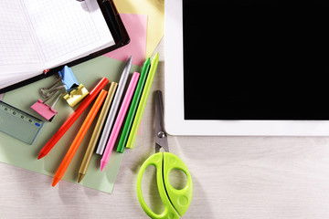 Tablet PC with office supplies on desktop background