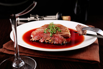 Glass of wine with grilled steak in wine sauce
