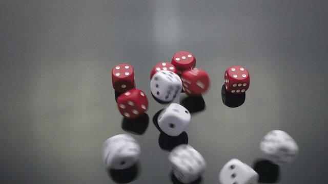 red and white dice cast on black slow motion