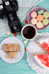 Different sweets and photo camera on table top view