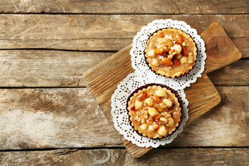 Mini cakes with nuts on wooden background