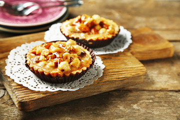 Mini cakes with nuts on wooden background