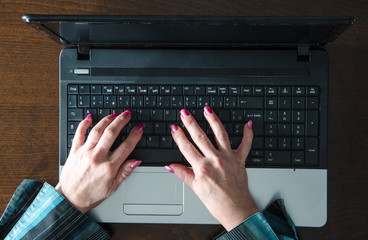 Female hands typing on a laptop