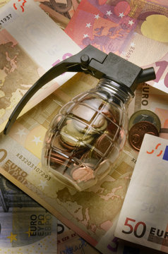 Transparent grenade filled with coins on euro notes