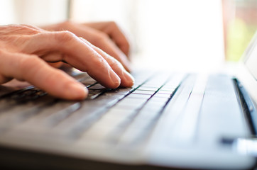 Hand typing on a laptop