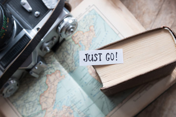 "Just go" book, map, camera, travel concept.