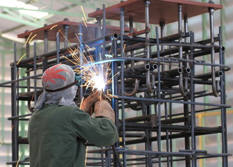 welder is welding steel frame in factory