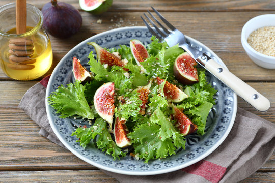 Light salad with figs, lettuce and honey in a plate on napkin