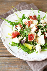 Delicious salad with arugula, slices of cheese and pears on a pl