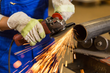 Worker cutting steel with angle grinder