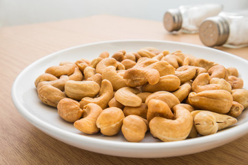 Cashew nuts on plate and salt shaker