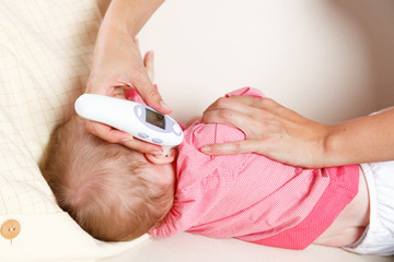 Baby with a digital thermometer