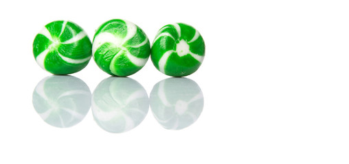 Green swirl peppermint candies over white background