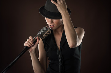 fashionable woman in a hat with a retro microphone