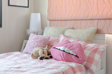 girl's bedroom in pink color with pillows and doll at home