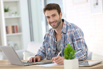 Fototapeta premium Businessman at home working on laptop