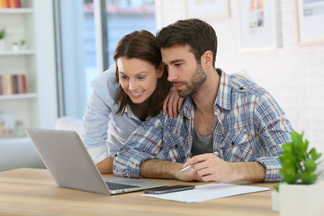 Couple at home websurfing on internet