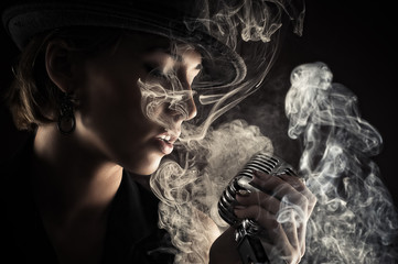 singer woman with retro microphone in smoke