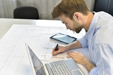 Designer in office working on project with laptop
