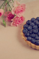 Tart with blueberry near roses