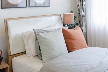 Fototapeta na wymiar orange color pillow on white bed in bedroom