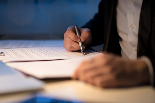Businessman working late signing a document or contract
