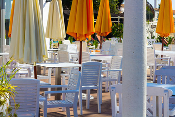 white chairs and tables with umbrellas orange