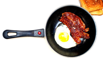 bacon and eggs in a frying pan
