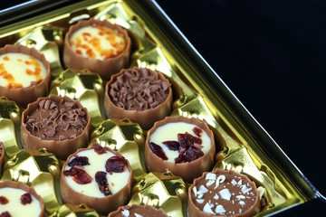Assorted chocolate confectionery on black background