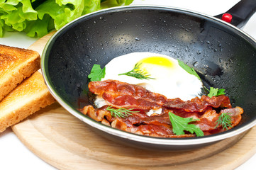 bacon and eggs in a frying pan