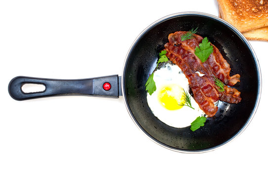 bacon and eggs in a frying pan