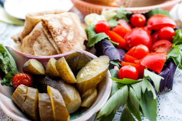 Vegetables, pancakes and pickles on the table
