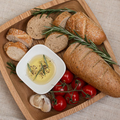 Bread with olive oil ,rosemary on the wooden plate.