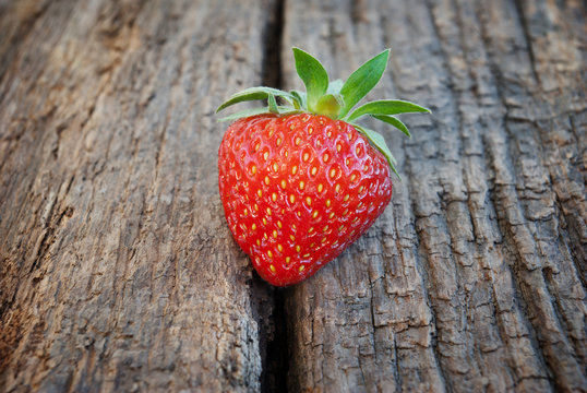Ripe red strawberries on a wooden background.
