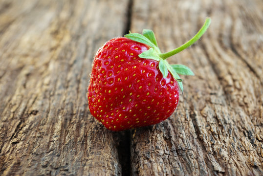 Ripe red strawberries on a wooden background.