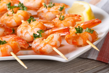 Delicious fried shrimp on wooden skewers close-up horizontal