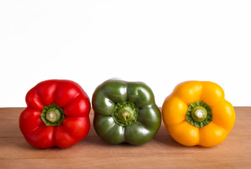Red, green and yellow pepper on a white background