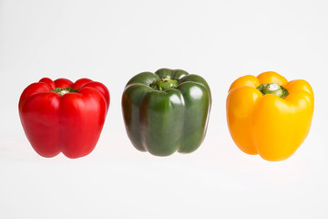 Red, green and yellow pepper on a white background