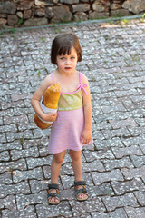 Adorable little girl holding  a loaf of bread