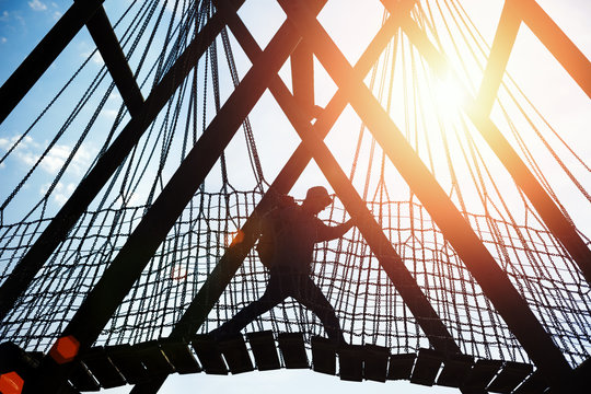 Silhouette Of A Traveler Walking Over Hanging Bridge