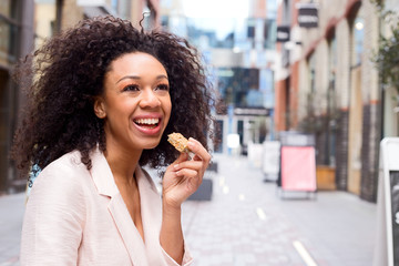 young woman enjoying a healthy snack in the street