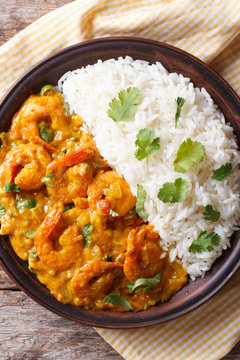 Shrimps curry with rice on a plate close-up. vertical top view