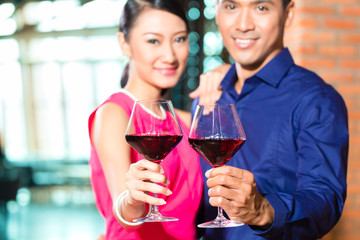 Asian couple with glass of red wine