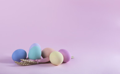Fototapeta na wymiar Colorful Easter eggs composition with sheaf of wheat horizontal